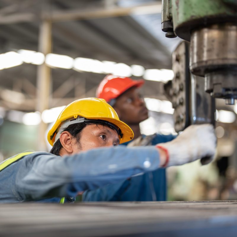 Professional asian workers and african man factory working at steel heavy machine. engineering training staff. Concept Engineer Operating and control in Factory with safety.