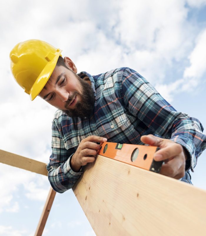 worker-with-hard-hat-level-checking-roof-timber